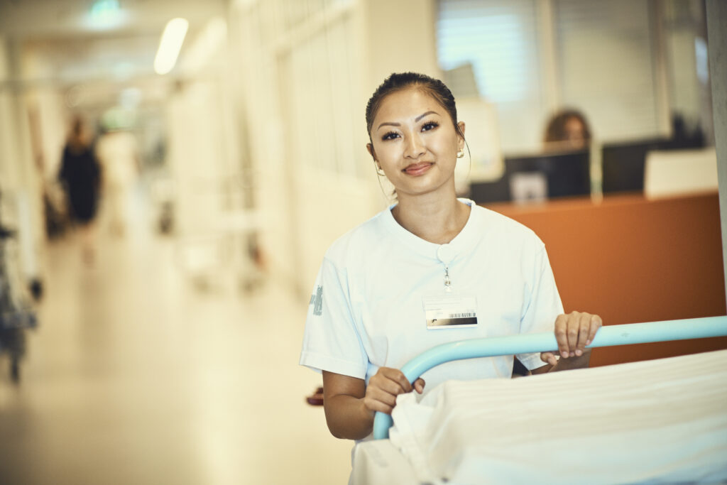 Sygeplejerske står ved en hospitalsseng